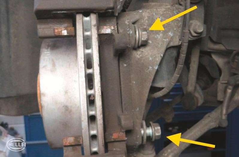 Befestigungsschrauben des Bremssattelträgers lösen und herausdrehen